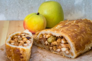 Taze elma, fındık ve ahşap bir zemin üzerine pudra şekeri ile Apple strudel. Üstten Görünüm. Yakın çekim