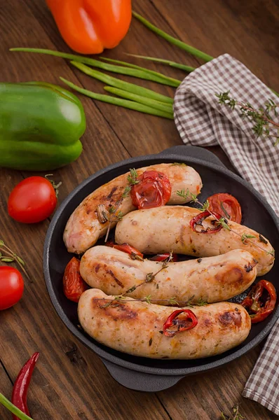 Saucisses grillées dans une poêle. Fond en bois. Vue de dessus. Gros plan — Photo