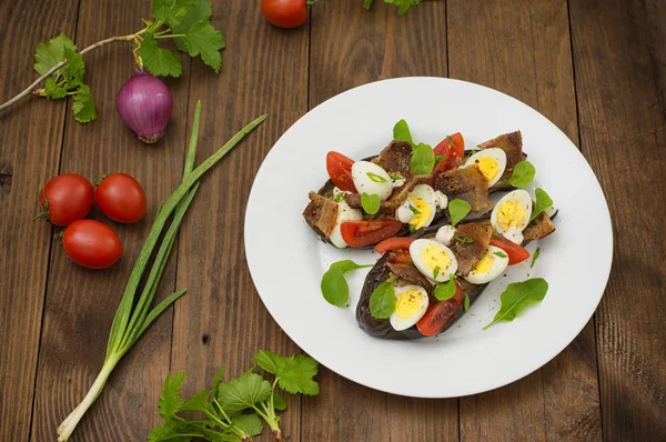 Bakad aubergine med bacon, vitlök och vaktelägg. Trä bakgrund. Ovanifrån. Närbild — Stockfoto