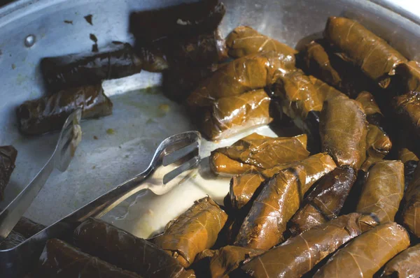 Dolma, aperitivo tradicional griego. hojas de vid rellenas de enfoque selectivo para la venta en el mercado. Vista superior. Primer plano — Foto de Stock