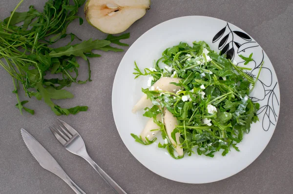 Salada com planta arugula verde, pêra e queijo cottage isolado. Estilo rústico. Fundo de pedra cinzenta. Close-up. Vista superior — Fotografia de Stock