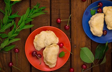 Ev yapımı mantı kiraz ile. Ahşap arka plan. Üstten Görünüm. Yakın çekim