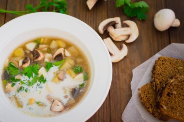 Yabani mantar, patates, yeşillik ve krema ile lezzetli çorba. Ahşap arka plan. Üstten Görünüm. Yakın çekim