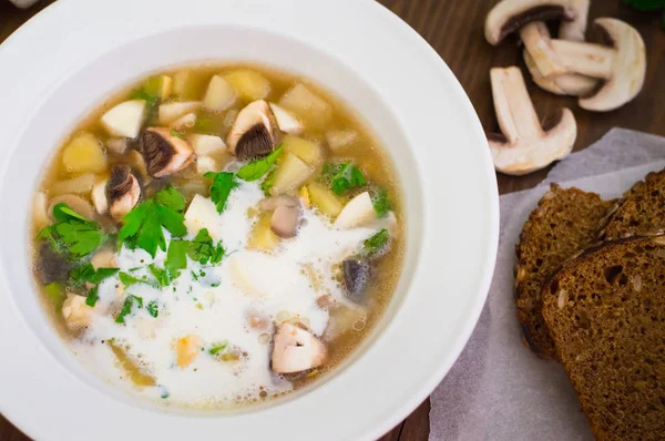 Köstliche Suppe mit Waldpilzen, Kartoffeln, Gemüse und Sahne. Holzuntergrund. Ansicht von oben. Nahaufnahme — Stockfoto