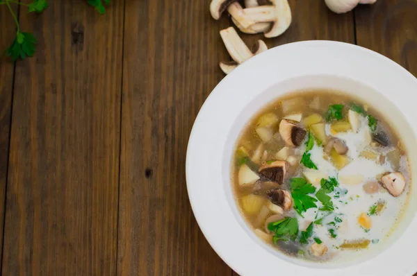 Köstliche Suppe mit Waldpilzen, Kartoffeln, Gemüse und Sahne. Holzuntergrund. Ansicht von oben. Nahaufnahme — Stockfoto