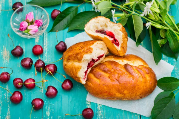 Patties con cerezas aisladas en el fondo de madera turquesa. Vista superior. Primer plano —  Fotos de Stock