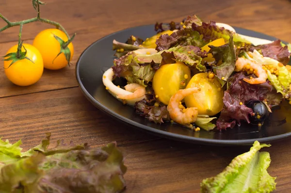 Salad segar dengan udang, tomat cherry kuning dan saus balsamic. pada latar belakang kayu. Close-up. Tampilan atas — Stok Foto