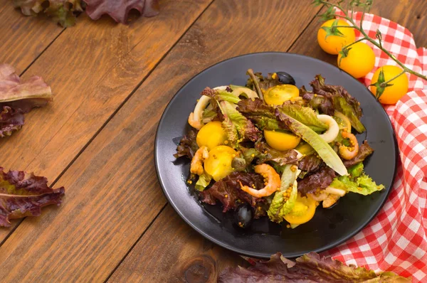 Fräsch mix sallad med räkor, gula körsbärstomater och balsamico sås. på trä bakgrund. Närbild. Ovanifrån — Stockfoto