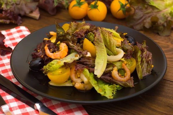 Fräsch mix sallad med räkor, gula körsbärstomater och balsamico sås. på trä bakgrund. Närbild. Ovanifrån — Stockfoto