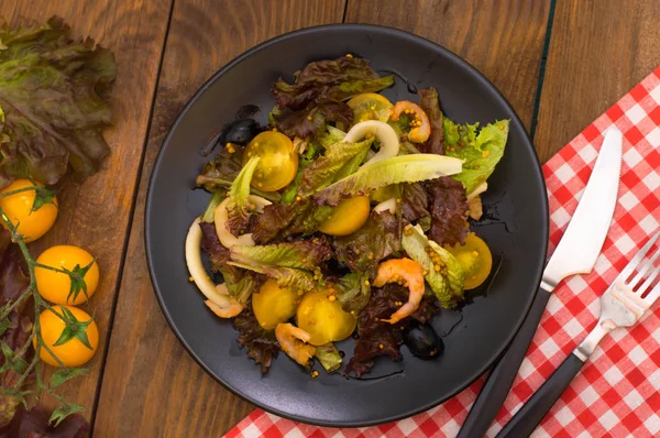 Salada de mistura fresca com camarões, tomates cereja amarelos e molho balsâmico. sobre fundo de madeira. Close-up. Vista superior — Fotografia de Stock