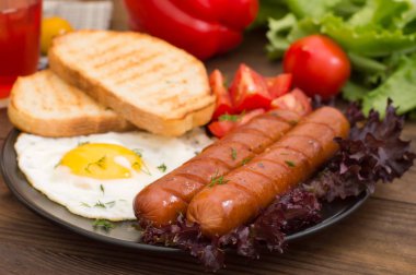 İngiliz kahvaltısı - ekmek, yumurta, sosis ve sebze salatası. Ahşap rustik arka plan. Yakın çekim. Üstten Görünüm