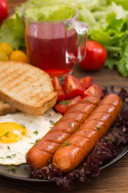 İngiliz kahvaltısı - ekmek, yumurta, sosis ve sebze salatası. Ahşap rustik arka plan. Yakın çekim. Üstten Görünüm