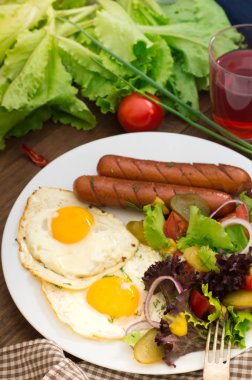 İngiliz kahvaltısı - ekmek, yumurta, sosis ve sebze salatası. Ahşap rustik arka plan. Yakın çekim. Üstten Görünüm