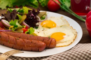 İngiliz kahvaltısı - ekmek, yumurta, sosis ve sebze salatası. Ahşap rustik arka plan. Yakın çekim. Üstten Görünüm