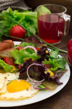 İngiliz kahvaltısı - ekmek, yumurta, sosis ve sebze salatası. Ahşap rustik arka plan. Yakın çekim. Üstten Görünüm