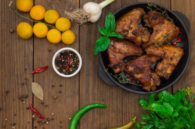 Tavuk kanadı pişirme tavada pişirdim. Seçici odak. Ahşap arka plan. Yakın çekim. Üstten Görünüm