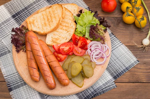 Ensemble de nourriture pour hot dog, saucisses, concombres en conserve, feuilles de laitue, tomates, oignons, croûtons sur le fond en bois. Gros plan. Vue du dessus — Photo