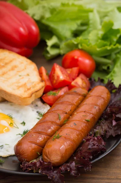 İngiliz kahvaltısı - ekmek, yumurta, sosis ve sebze salatası. Ahşap rustik arka plan. Yakın çekim. Üstten Görünüm