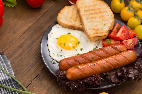 Petit déjeuner anglais - pain grillé, oeuf, saucisses et salade de légumes. Fond rustique en bois. Gros plan. Vue du dessus — Photo