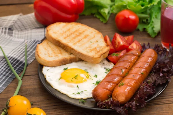Англійський сніданок - тост, яйця, сосиски та овочі салат. Дерев'яні сільському стилі тла. Крупний план. Вид зверху — стокове фото