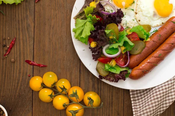 İngiliz kahvaltısı - ekmek, yumurta, sosis ve sebze salatası. Ahşap rustik arka plan. Yakın çekim. Üstten Görünüm