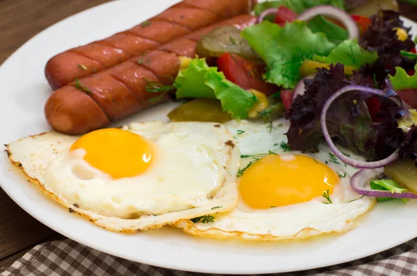 Англійський сніданок - тост, яйця, сосиски та овочі салат. Дерев'яні сільському стилі тла. Крупний план. Вид зверху — стокове фото