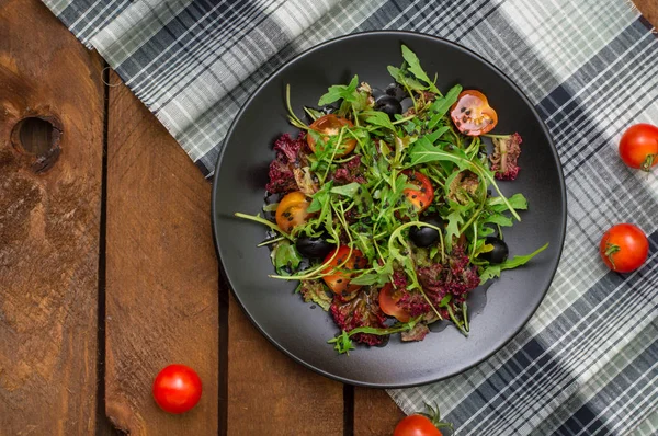 Čerstvý salát s rukolou, krevety, cherry rajčaty a avokádem. Dřevěné pozadí. Detail. Pohled shora — Stock fotografie