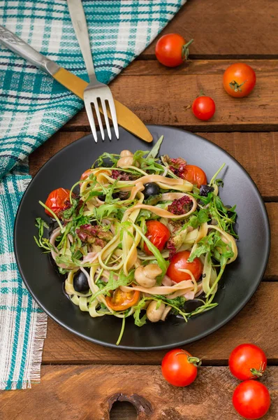 Italian bucatini with shrimp, arugula and cherry tomatoes. Wooden background. Close-up. Top view — Stock Photo, Image