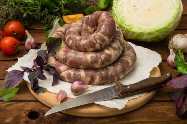 Ahşap arka plan üzerinde beyaz bir tabak içinde ham taze sosis. Üstten Görünüm. Yakın çekim