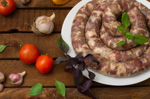 Ahşap arka plan üzerinde beyaz bir tabak içinde ham taze sosis. Üstten Görünüm. Yakın çekim