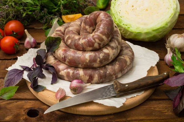 Ahşap arka plan üzerinde beyaz bir tabak içinde ham taze sosis. Üstten Görünüm. Yakın çekim