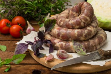 Ahşap arka plan üzerinde beyaz bir tabak içinde ham taze sosis. Üstten Görünüm. Yakın çekim