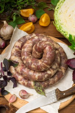 Ahşap arka plan üzerinde beyaz bir tabak içinde ham taze sosis. Üstten Görünüm. Yakın çekim