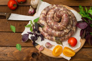 Ahşap arka plan üzerinde beyaz bir tabak içinde ham taze sosis. Üstten Görünüm. Yakın çekim