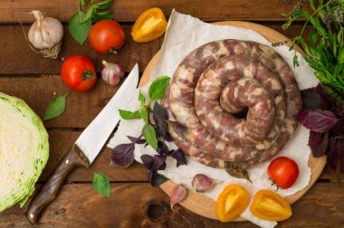 Ahşap arka plan üzerinde beyaz bir tabak içinde ham taze sosis. Üstten Görünüm. Yakın çekim