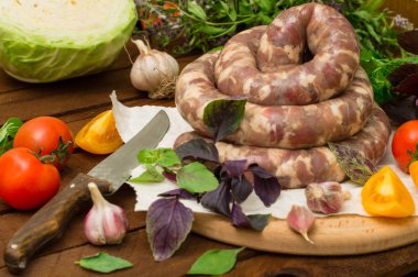 Ahşap arka plan üzerinde beyaz bir tabak içinde ham taze sosis. Üstten Görünüm. Yakın çekim