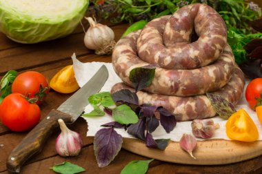 Ahşap arka plan üzerinde beyaz bir tabak içinde ham taze sosis. Üstten Görünüm. Yakın çekim