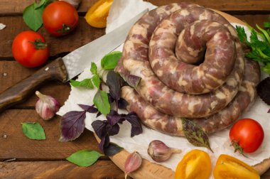 Ahşap arka plan üzerinde beyaz bir tabak içinde ham taze sosis. Üstten Görünüm. Yakın çekim