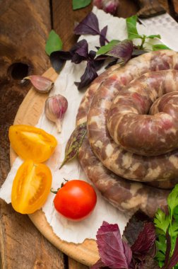 Ahşap arka plan üzerinde beyaz bir tabak içinde ham taze sosis. Üstten Görünüm. Yakın çekim