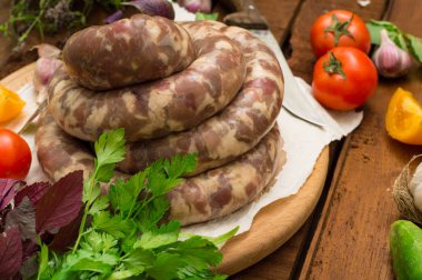 Ahşap arka plan üzerinde beyaz bir tabak içinde ham taze sosis. Üstten Görünüm. Yakın çekim