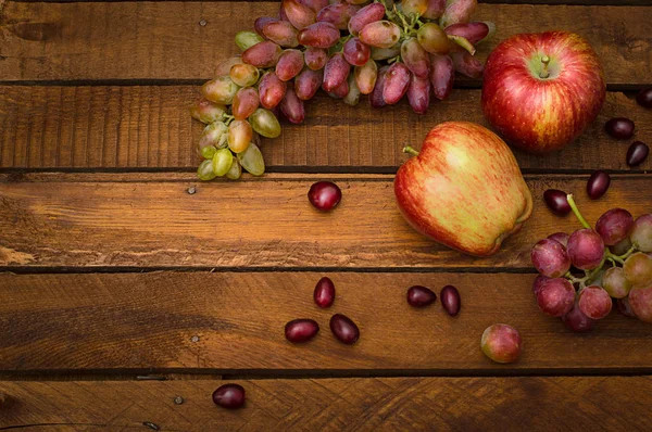 Manzanas y uvas sobre un fondo rústico de madera. Bodegón para la acción de gracias con frutas de otoño. Enfoque selectivo. Vista superior —  Fotos de Stock