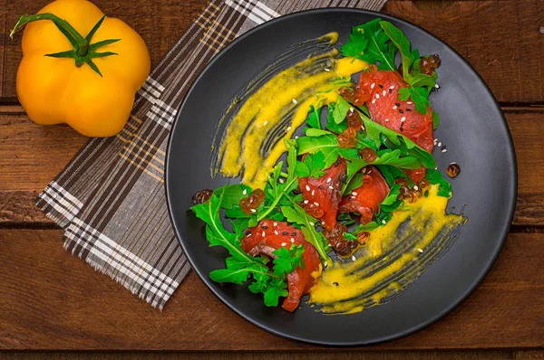 Salada de salmão, arugula, caviar vermelho e molho holandês Hollandez. Fundo rústico de madeira. Vista superior. Foco seletivo — Fotografia de Stock