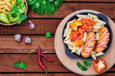 Sosis ve lecho ile makarna. Ahşap rustik arka plan. Seçici odak. Üstten Görünüm