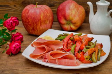 Jamon ızgara sebzeler ile. İspanya mutfağı. Ahşap rustik arka plan. Üstten Görünüm