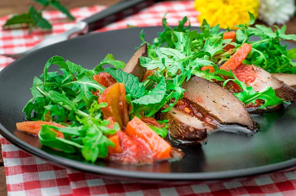 Warmer Salat, Ente mit Rucola, leckeres, modisches Essen, neue Gerichte. rustikalen hölzernen Hintergrund. Ansicht von oben — Stockfoto