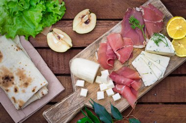 Jamon peynir bir ahşap tahta üzerinde farklı tipteki. Ahşap rustik arka plan. Üstten Görünüm