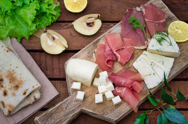 Jamon peynir bir ahşap tahta üzerinde farklı tipteki. Ahşap rustik arka plan. Üstten Görünüm