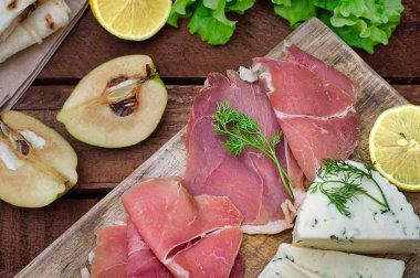 Jamon peynir bir ahşap tahta üzerinde farklı tipteki. Ahşap rustik arka plan. Üstten Görünüm