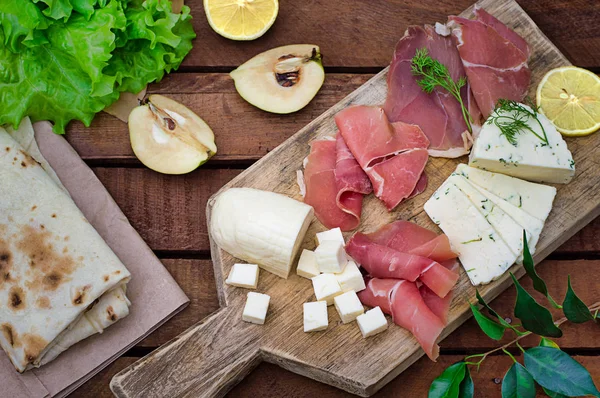 Jamon peynir bir ahşap tahta üzerinde farklı tipteki. Ahşap rustik arka plan. Üstten Görünüm