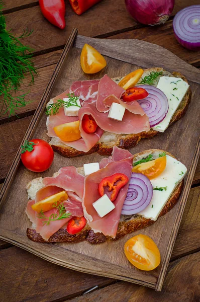 Ciabatta-Sandwich mit Salatblättern, Marmeladenserrano und Mozzarella. Ansicht von oben. Selektiver Fokus. Holz rustikalen Hintergrund — Stockfoto